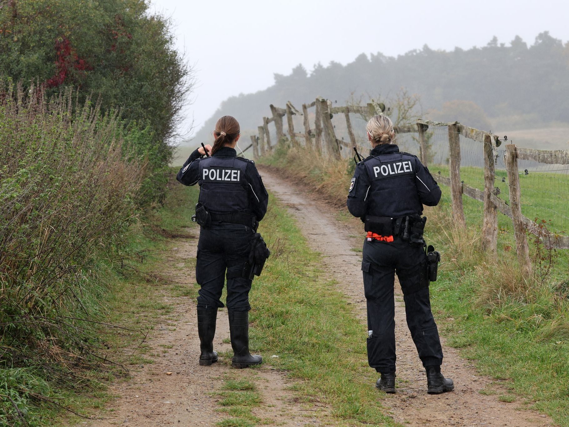 Polizisten sperren einen Weg zum Fundort einer Kinderleiche. Polizisten sperren einen Weg zum Fundort einer Kinderleiche.