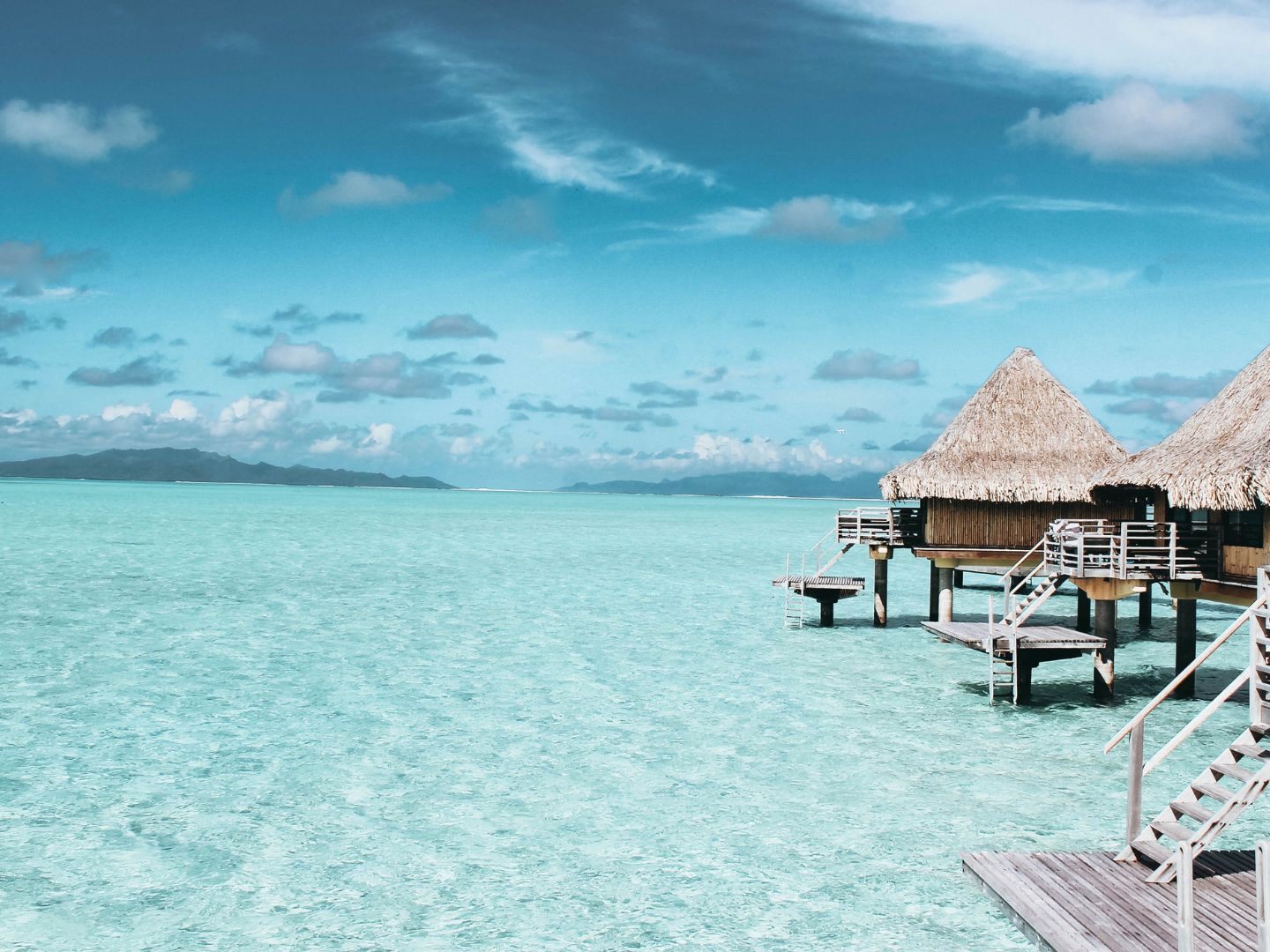 Überwasser-Bungalows auf türkisfarbenem Meer in der Südsee – Symbolbild für die schönsten Inseln der Welt 2025.