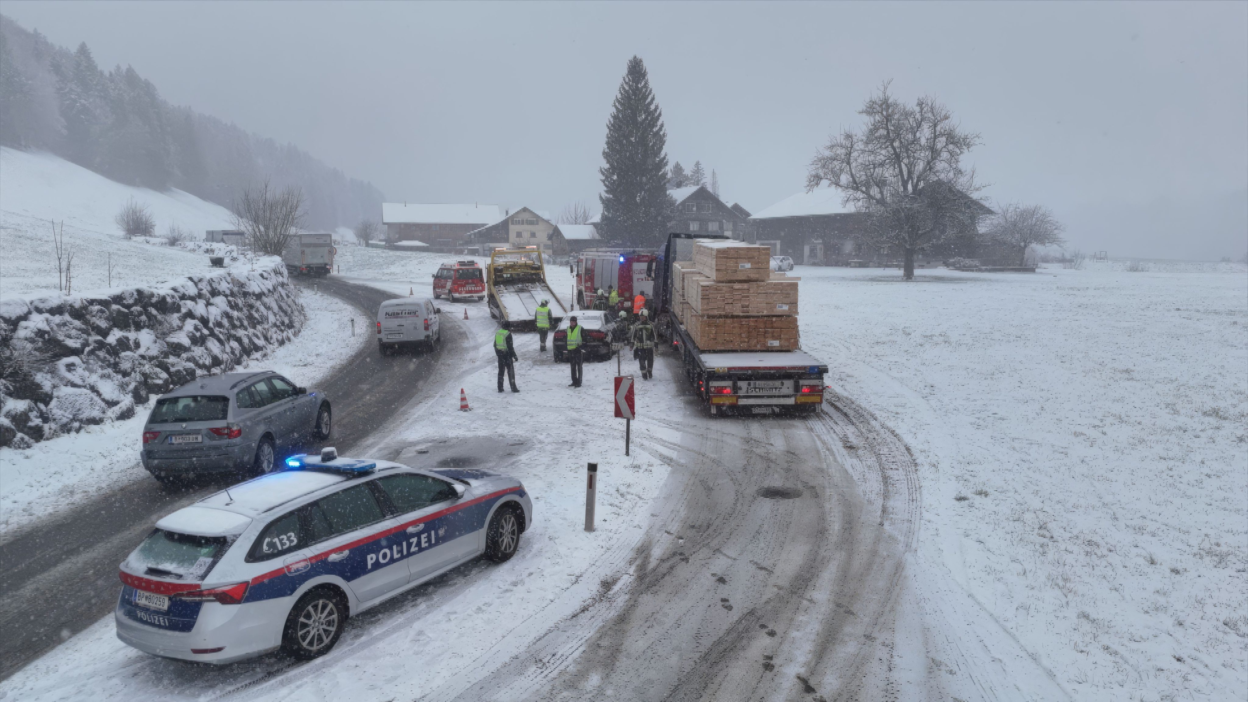 Polizei, Feuerwehr, Rettung und Abschleppdienst arbeiten bei winterlichen Bedingungen Hand in Hand.