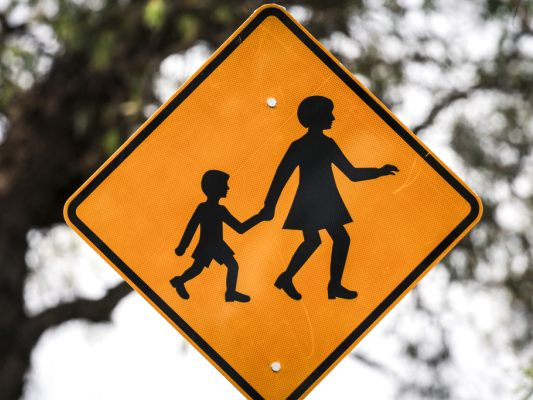 Auf dem Bild sieht man ein Sicherheitsschild, das auf Eltern und Kinder hinweist.