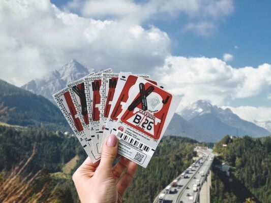 Auf dem Bild sieht man eine Hand, die mehrere Klebevignette in Feuerrot hält.