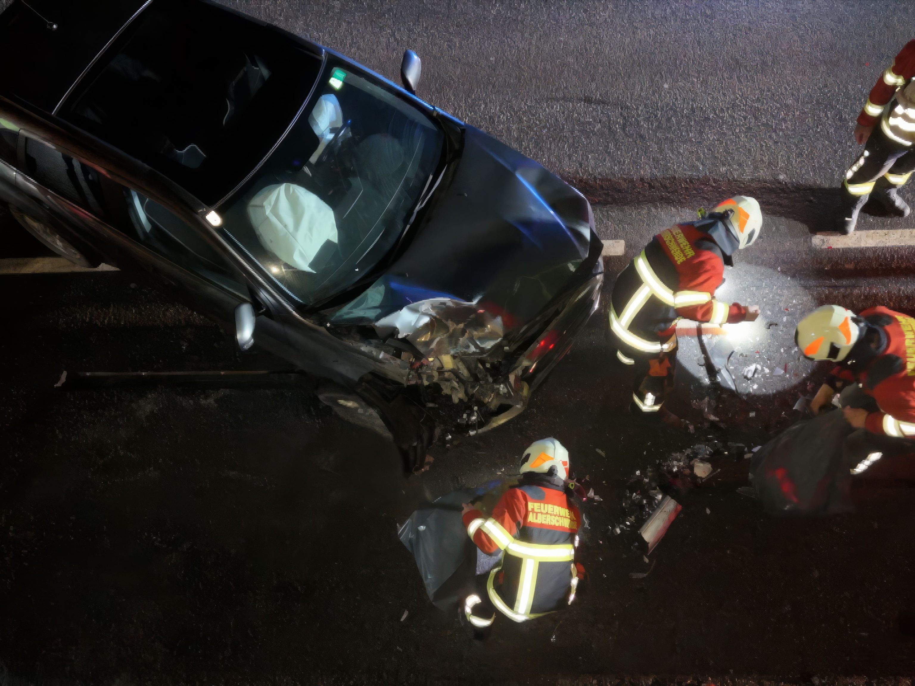 Feuerwehrkräfte im Einsatz rund um das beschädigte Fahrzeug auf der L200.