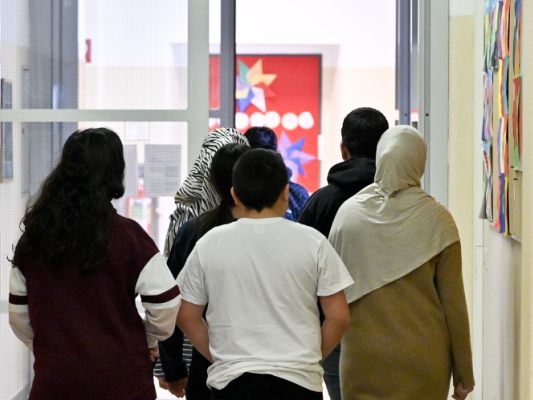 Auf dem Bild sieht man Kinder in einer Schule in Wien. 2 Schülerinnen tragen ein Kopftuch.